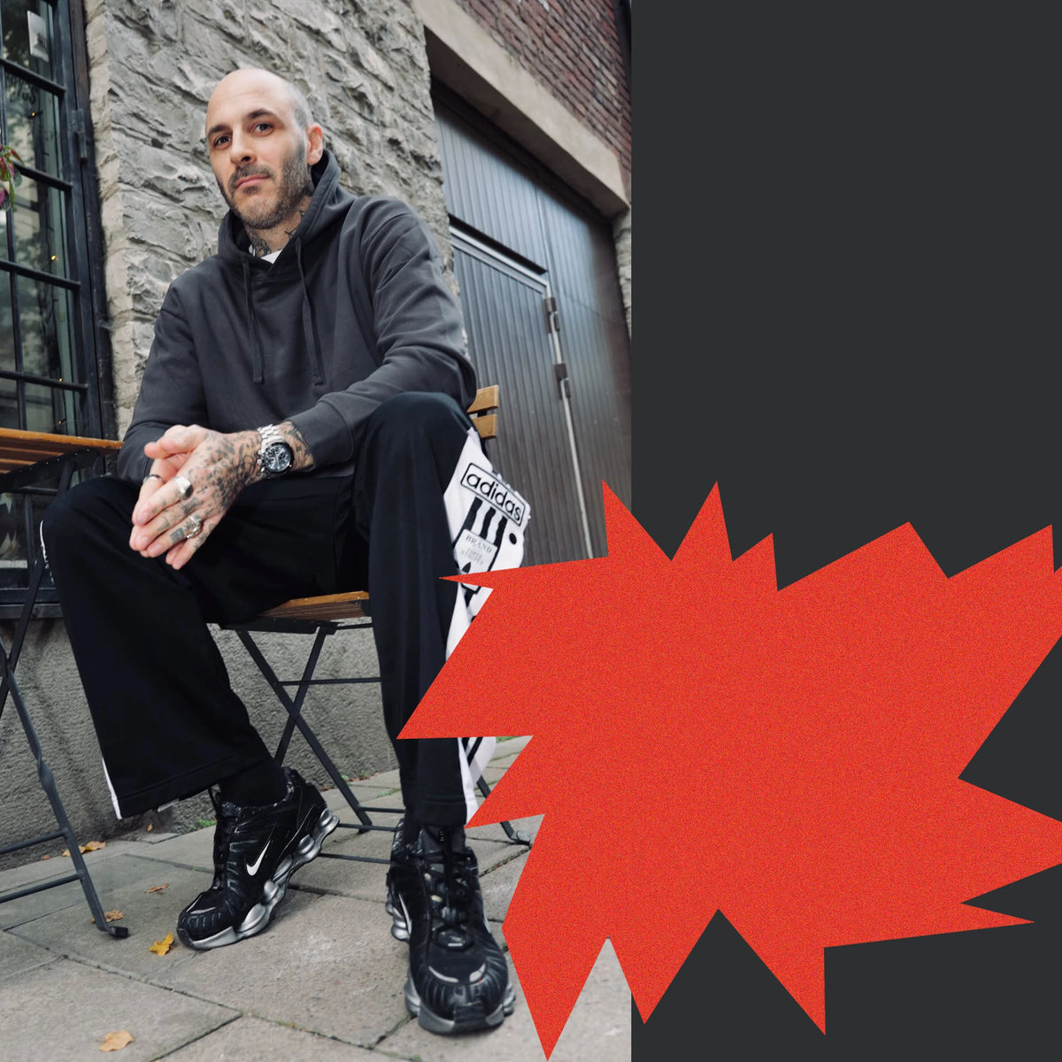 Niklas Hallberg sits on a folding chair outside a stone building, hands folded, looking into the camera.
